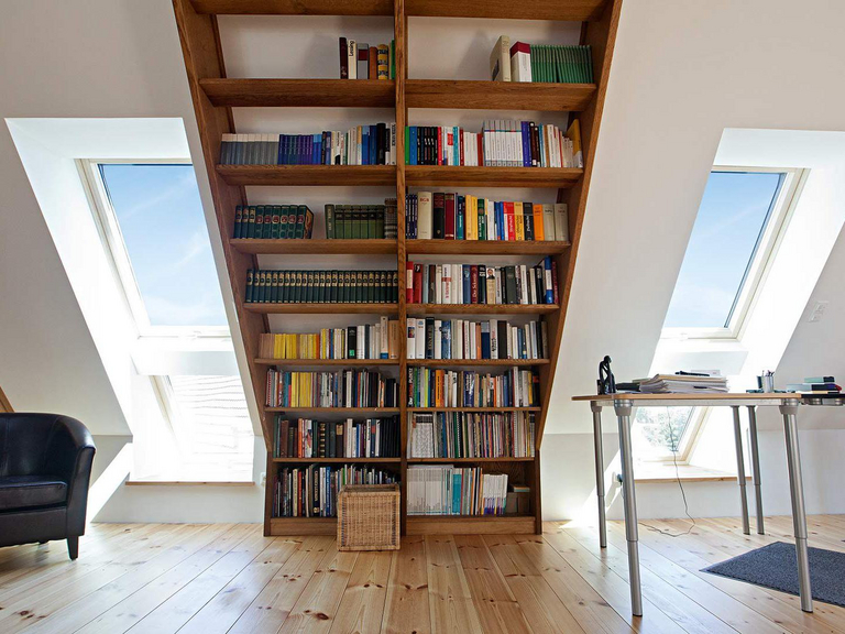Bookshelf in an attic apartment with roof window in tandem installation method