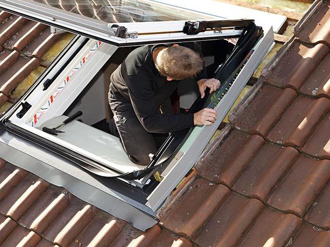 A craftsman installing a roof window