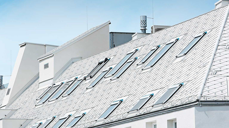 Roof of a modern white house with several skylights