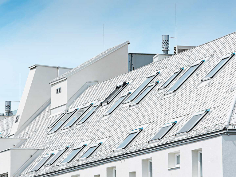 Roof of a modern white house with several skylights