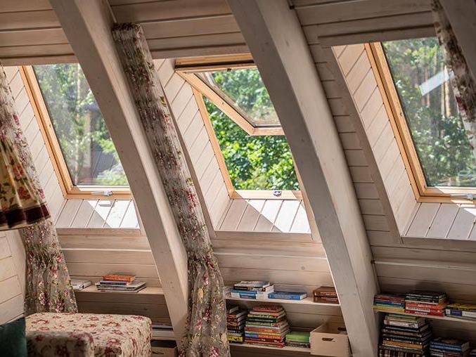 Cosy reading corner in a wooden house with roof windows also made of wood