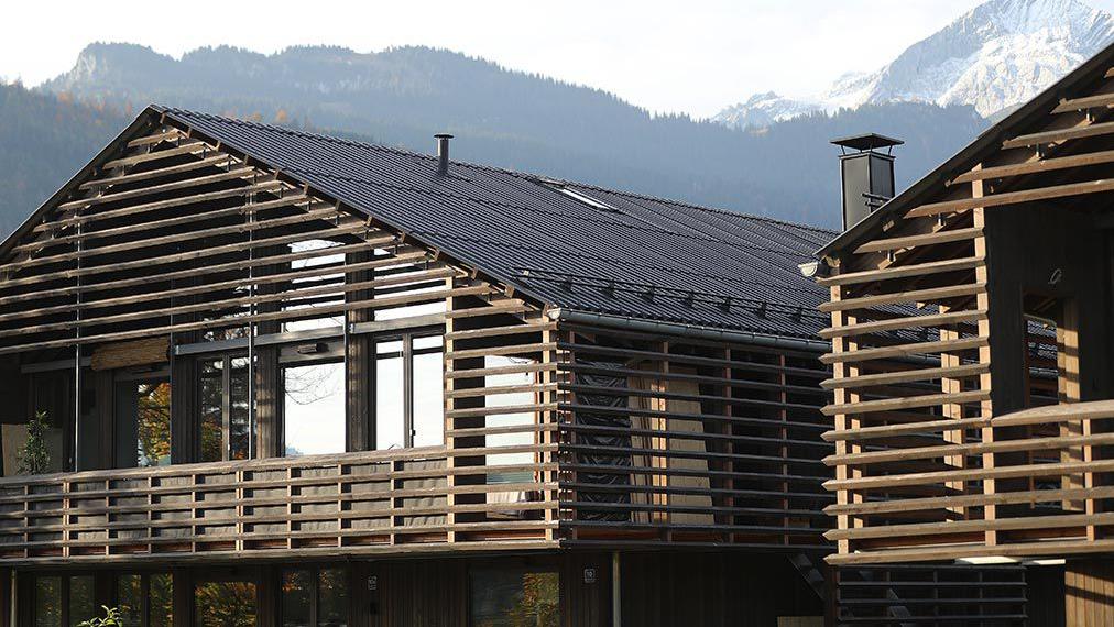 Two wooden houses with mountains in the background